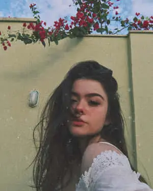 Young beautiful woman lounging in a flowers field.