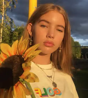 A young girl stares off into the horizon while admiring a beautiful sunset