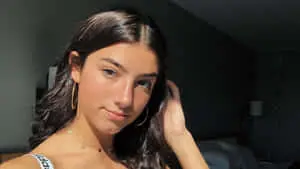 a woman in a black top and hoop earrings