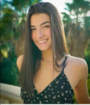 a young woman smiling in front of palm trees