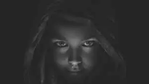 a black and white photo of a girl with a hood