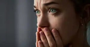 a woman is holding her hand over her mouth