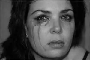 a woman is crying with her eyes closed