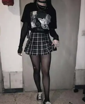 a girl wearing a plaid skirt and a t shirt