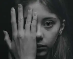 a girl with her hands covering her face