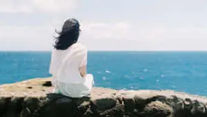 A lonely girl stands, isolated and alone.