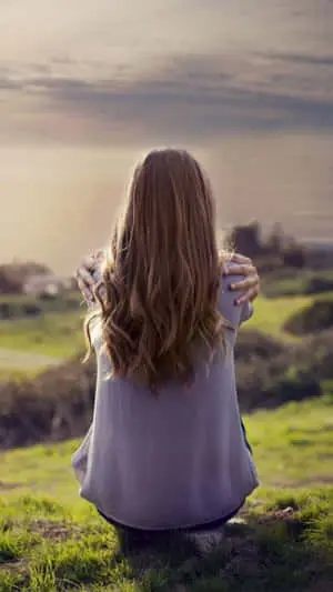 Image  A Lonely Girl Sitting On The Edge of a Beach